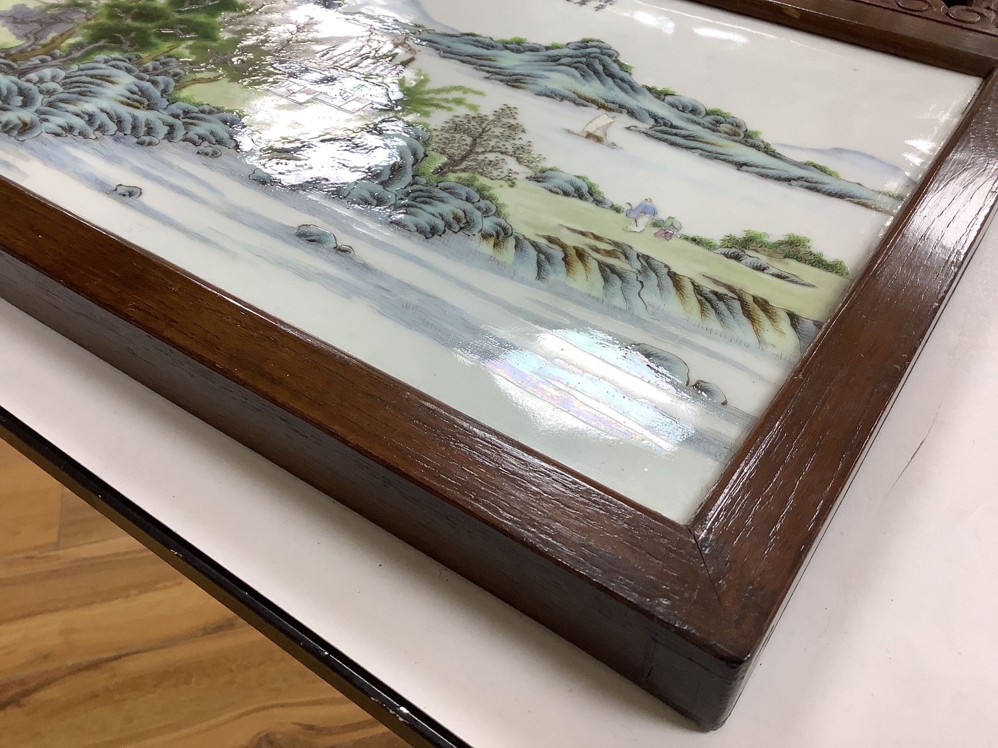 A 20th century Republic period porcelain plaque decorated in coloured enamels with landscape scene, inscription mark 24 x 38cm in carved frame